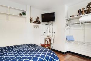 シアトルにあるBeacon Hill Hideawayのベッドルーム1室(ベッド1台、壁にテレビ付)