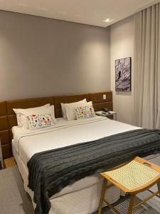 a bedroom with a large white bed with pillows at Hotel Estilo de Minas in Diamantina