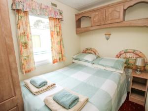 a small bedroom with a bed and a window at 1 Old Orchard in Much Wenlock