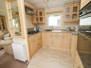 a kitchen with wooden cabinets and a sink at 4 Old Orchard in Much Wenlock