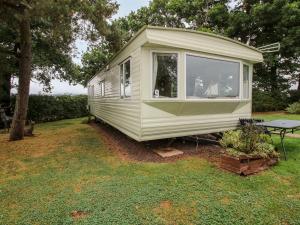 a green caravan sitting on the grass in a yard at 9 Old Orchard in Much Wenlock