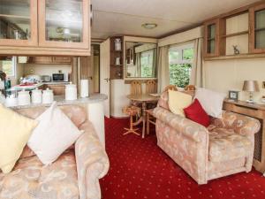 a living room with two couches and a kitchen at 2 Old Orchard in Much Wenlock