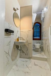 Baño blanco con lavabo y espejo en Borgo Nuovo Housing en Fucecchio