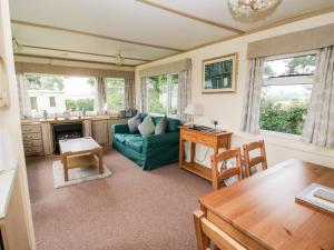 ein Wohnzimmer mit einem grünen Sofa und einem Tisch in der Unterkunft 7 Old Orchard in Much Wenlock