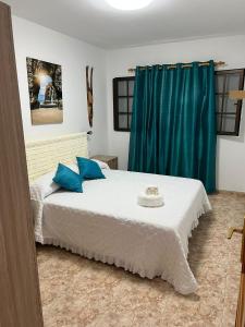 Casa La Orilla 2 في بلايا هوندا: غرفة نوم مع سرير أبيض كبير مع وسائد زرقاء