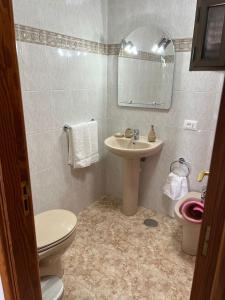 a bathroom with a sink and a toilet and a mirror at Casa La Orilla 2 in Playa Honda