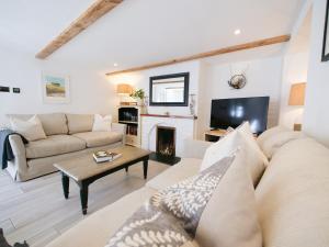 a living room with a couch and a fireplace at Padstow Escapes - Captains Cottage in Padstow