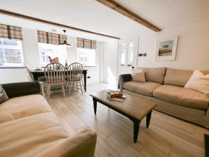 a living room with a couch and a table at Padstow Escapes - Captains Cottage in Padstow