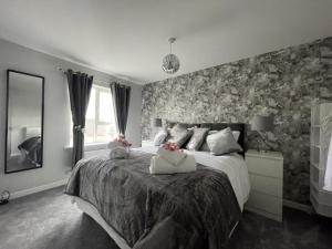 a bedroom with a large bed with floral wallpaper at Home From Home Northampton in Northampton