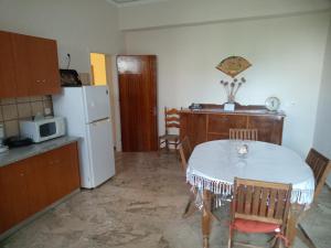a kitchen with a white table and a white refrigerator at Tom House 1 in Filiatra