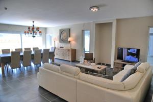 a living room with a couch and a dining room at Petit coin de paradis in Somme-Leuze