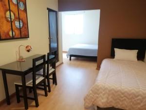 - une chambre avec un lit, un bureau et un lit dans l'établissement Miraflores Rooms, à Lima