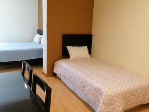 - une chambre avec deux lits, une table et un lit dans l'établissement Miraflores Rooms, à Lima