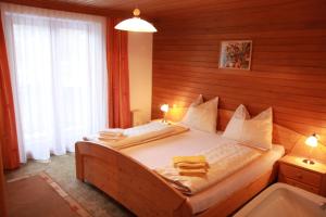 ein Schlafzimmer mit einem Bett mit einer Holzwand in der Unterkunft Landhaus Glockner in Bruck an der Großglocknerstraße