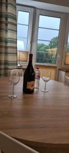 una bottiglia di vino e due bicchieri su un tavolo di Neu Schweizerhaus 29 a Karpacz Altre 2 foto