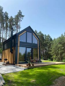 Borków的住宿－Brama do lasu - Domek Energia，现代房屋设有玻璃窗和草坪