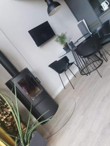 salon z kominkiem i czarnymi krzesłami w obiekcie Domek Energia w mieście Borków