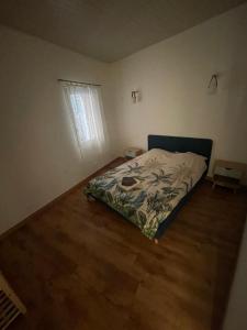 リエにあるBABILOC Bohème Appartementのベッドと木の床のある寝室 +4枚の写真