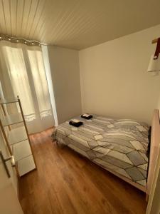 a bedroom with a bed and a wooden floor at BABILOC Bohème Appartement in Riez