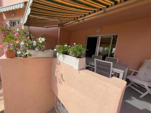 a patio with potted plants on a wall at Casa adosada con piscina a 5 minutos de la playa . in Aguadulce