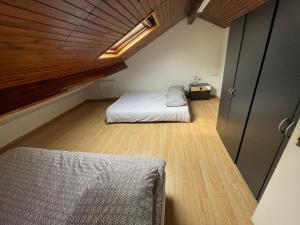 Habitación pequeña con cama y techo de madera. en Agréable appartement dans une maison en Saint-Denis