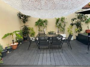 a patio with a table and chairs and potted plants at Agréable appartement dans une maison in Saint-Denis