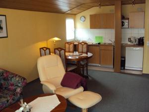 a living room with a table and a kitchen at Ferienwohnungen Hasenpatt in Bad Sachsa +6 photos