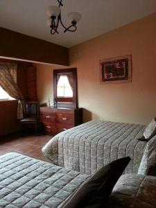 1 dormitorio con 2 camas, vestidor y ventana en Villas San Francisco, en Huichapan