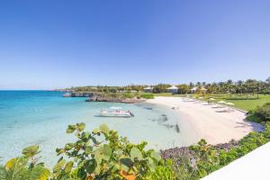 a boat in the water on a beach at The Cove Eleuthera in Gregory Town