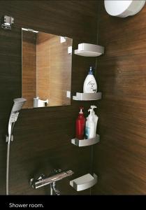 La salle de bains est pourvue d'un miroir, d'un lavabo, de savon et de shampoing. dans l'établissement Da Fern, à Sakaiminato
