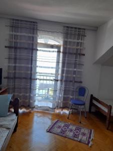 een woonkamer met een blauwe stoel en een raam bij Villa Gjorgi in Ohrid