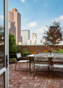 a patio with a table and chairs and a view of the city at Nine Orchard in New York