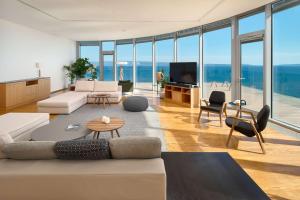 uma sala de estar com um sofá e uma televisão em Radisson Blu Resort & Spa em Split