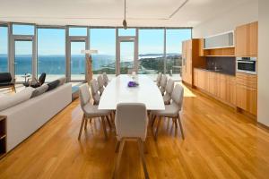 una cucina e una sala da pranzo con tavolo e sedie bianchi di Radisson Blu Resort & Spa a Spalato (Split)