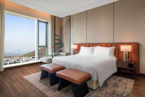 a bedroom with a large bed and a large window at Radisson Blu Hotel & Spa, Nashik in Nashik