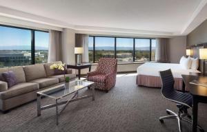 ミルピータスにあるSonesta San Jose - Milpitasのベッドと大きな窓が備わるホテルルームです。
