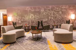 a lobby with chairs and a mural on the wall at The Elite Narasapura, a member of Radisson Individuals in Narasapura
