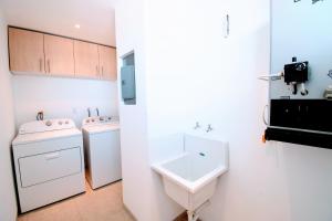 a bathroom with a sink and a washing machine at Terra Residencial in Veracruz