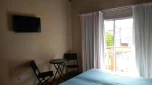 a bedroom with a bed and a window with a table and chairs at DUPLEX TIERRA DE MAR 2 in San Clemente del Tuyú