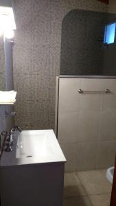 a bathroom with a sink and a shower with a mirror at DUPLEX TIERRA DE MAR 2 in San Clemente del Tuyú