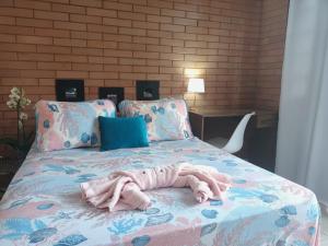 um cobertor numa cama num quarto em EccO Capricornio em Caraguatatuba