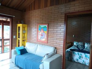 a living room with a couch in a brick wall at EccO Capricornio in Caraguatatuba