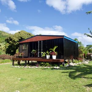 a black building with potted plants in a yard at 'ARE PEPE one bedroom container style unit in Rarotonga