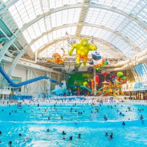 a large water park with people in a swimming pool at The Flats King Bed- EWR/Penn Station in Newark