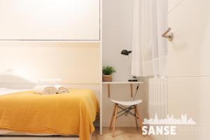 ein Schlafzimmer mit einem gelben Bett und einem Stuhl in der Unterkunft Ondarreta Beach by SanSe Holidays in San Sebastián