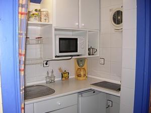 eine kleine Küche mit Mikrowelle und Spüle in der Unterkunft Casa Rural El Cubano in La Fregeneda