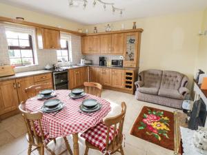 eine Küche mit einem Tisch und Stühlen im Zimmer in der Unterkunft Belladrihid Cottage in Ballysadare