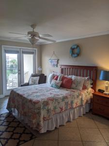 a bedroom with a bed and a ceiling fan at Biloxi Beach Condo in Biloxi