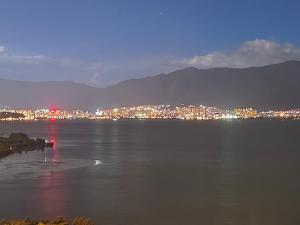 a view of a city from the water at night at Super Invincible All Seaview Villa in Dali