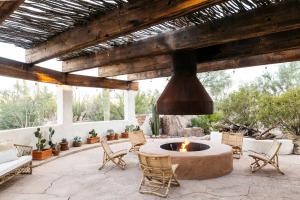 an outdoor patio with a fire pit and chairs at The JTH Tucson in Tucson
